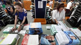 Des employées de 3ma group travaillent à la mise sous pli des professions de foi des candidats aux élections législatives à Rouffach, dans le Haut-Rhin, le 19 juin 2024