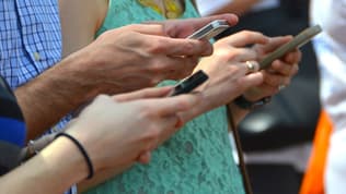 Des personnes avec des téléphones (Photo d'illustration).