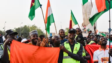 Des partisans de l'Alliance des États du Sahel (AES) brandissent des drapeaux alors qu'ils célèbrent le départ du Mali, du Burkina Faso et du Niger de la Communauté économique des États de l'Afrique de l'Ouest (CEDEAO), à Niamey, le 28 janvier 2024.