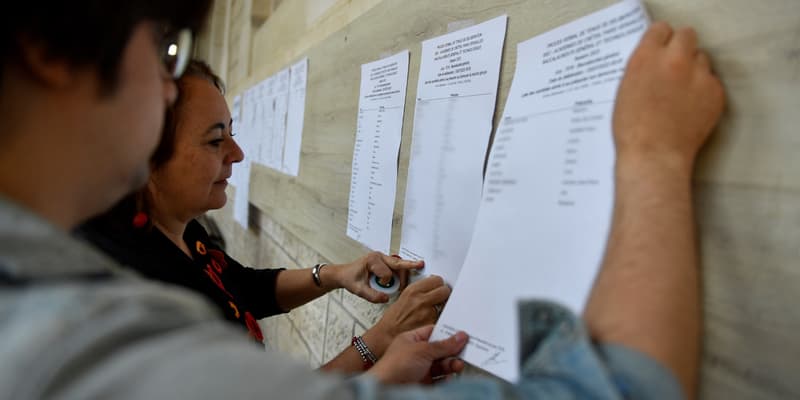 La directrice du lycée Voltaire affiche les résultats du baccalauréat sur une façade de l'établissement à Paris le 4 juillet 2023. (Illustration)