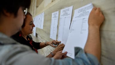 La directrice du lycée Voltaire affiche les résultats du baccalauréat sur une façade de l'établissement à Paris le 4 juillet 2023 (photo d'illustration)