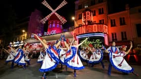 Des danseuses et danseurs devant le cabaret du Moulin Rouge lors de l'inauguration de ses nouvelles ailes, le 5 juillet 2024 à Paris