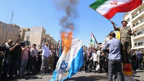 Des Iraniens brûlent un drapeau israélien lors des commémorations annuelles de la Journée de Quds (Jérusalem) et des funérailles de sept membres du Corps des gardiens de la révolution tués lors d'une attaque contre l'annexe consulaire du pays à Damas, que Téhéran a imputée à Israël, le 5 avril 2024 à Téhéran. 