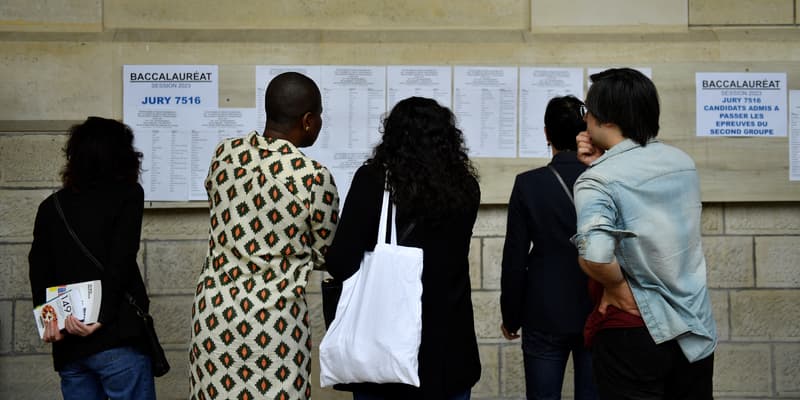 Des professeurs et des élèves regardent les résultats du baccalauréat (examen de fin d'études secondaires) au lycée Voltaire à Paris, le 4 juillet 2023. Photo d'illustration