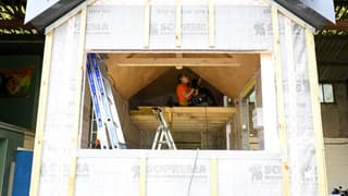 Karine, en apprentissage, travaille sur une "tiny house" construite par des sans-abri, le 28 avril 2022 à Séné, dans le Morbihan