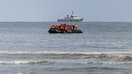 Des migrants montent à bord d'un bateau de passeurs pour tenter de traverser la Manche, sur la plage de Gravelines, près de Dunkerque, dans le nord de la France, le 26 avril 2024.