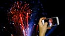 Une femme photographie le feu d'artifice du Nouvel An à Barcelone (Espagne) le 31 décembre 2016 (photo d'illustration)